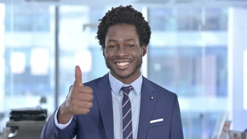 Smiling Young Adult Gives Thumbs Up in Office
