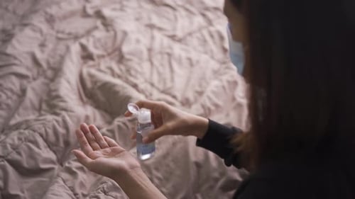 Woman Using Hand Sanitizer at Home