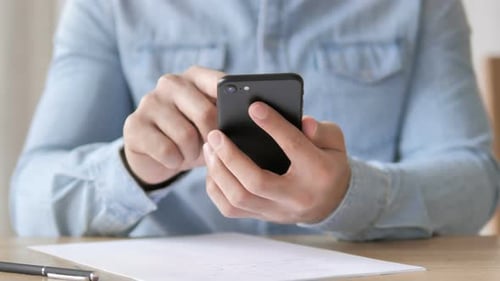 Person Using Phone at Desk Close Up