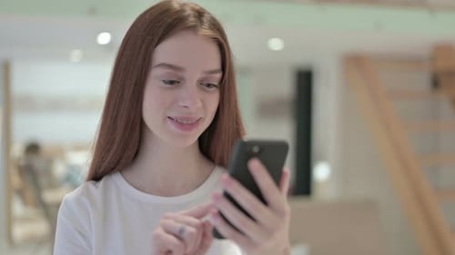 Young Woman Using Mobile Phone in Home