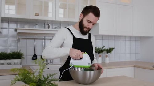 Man Using Electric Mixer in Modern Kitchen