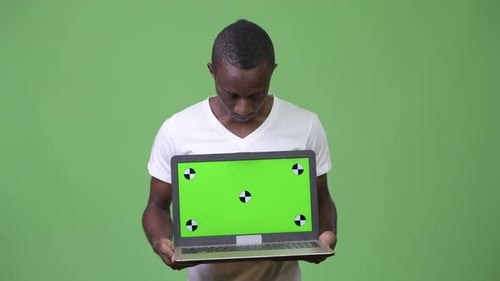 Young Adult Holds Laptop With Green Screen Display