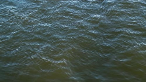 Wasseroberfläche mit ruhigen irisierenden Wellen