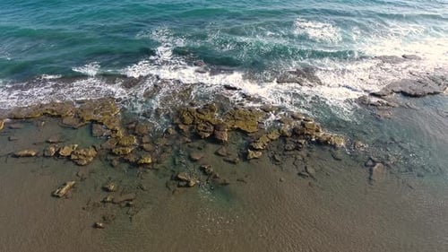 Arrecife rocoso poco profundo entre el mar y la playa