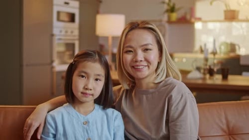 Young Woman and Child Smiling Together at Home