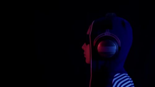 Person Wearing Headphones in Dark Futuristic Theme