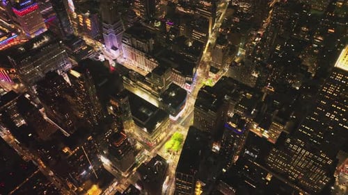 Cars Driving on Street Between High Rise Buildings in Night City