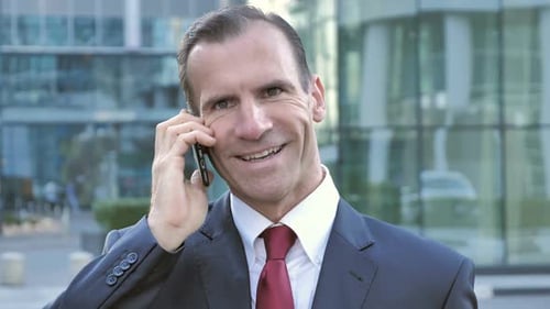 Smiling Businessman Talking on the Phone in the City