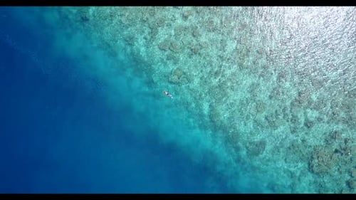 Guy and girl happy together on paradise seashore beach adventure by aqua blue water and white sandy