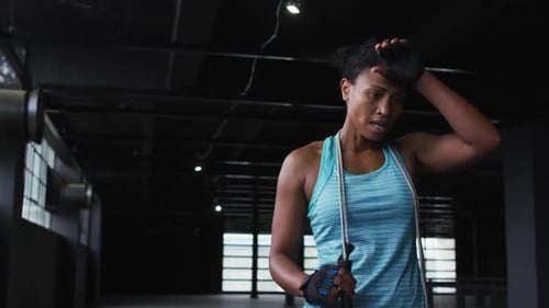 African american woman tired after skipping the rope in an empty urban building