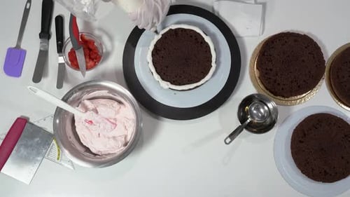 Assembling Delicious Chocolate Cake With White Cream Surface