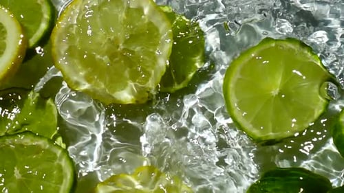 Lemon and Lime Slices Splashing in Water