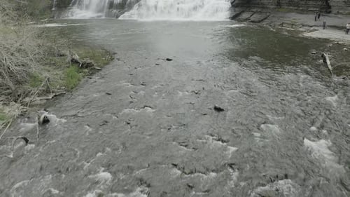 Un tiro de Zumbido tripulado bajo, revelando una gran cascada que avanza y se desplaza hacia arriba.