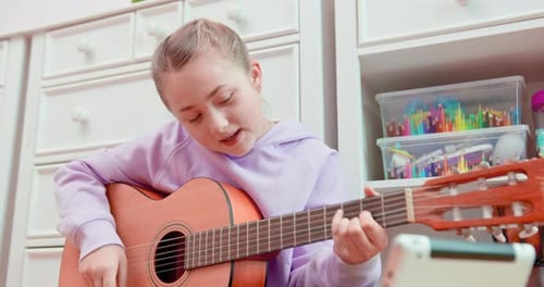 Girl Plays Acoustic Guitar and Sings at Home