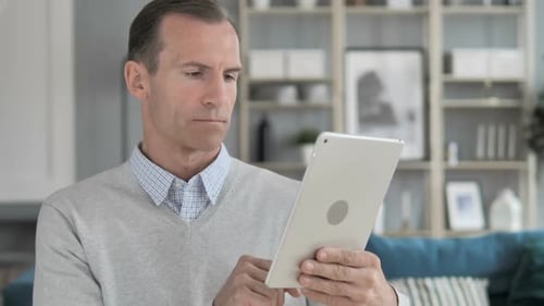 Man Using Silver Tablet Device Indoors