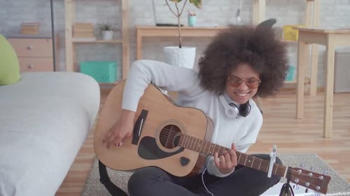 Smiling Woman Plays Guitar and Sings at Home