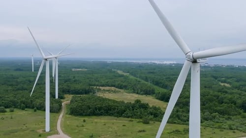 Luftaufnahme einer leistungsstarken Windturbinenfarm zur Energieerzeugung am schönen bewölkten Himmel