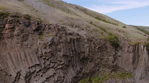 Steep Cliff in Studlagil Canyon and Mountain Silhouette in the Background