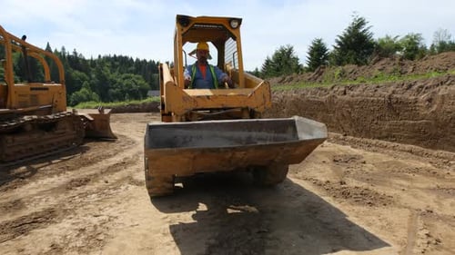 Construction Worker Operating Yellow Skid-Steer Loader