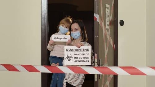 Mother and Child Holding Quarantine and Stay Safe Signs