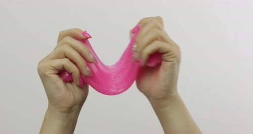 Woman Hands Playing Oddly Satisfying Pink Slime on White Background. Antistress