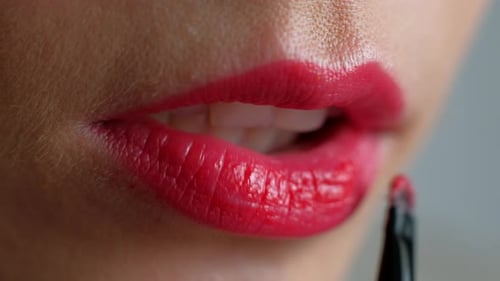 Woman Applies Bright Red Lipstick with Brush, Close Up