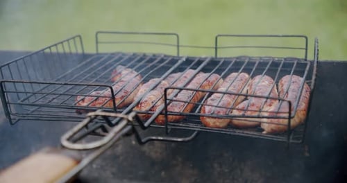 Slow Motion. Sausages Are Fried on an Open Fire, Close Up