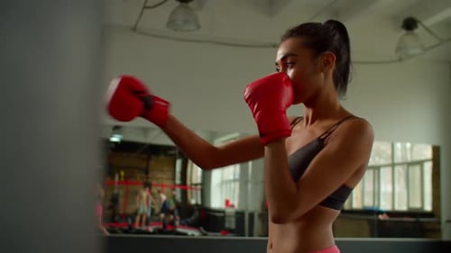 Fit Woman Boxing With Punching Bag in Gym