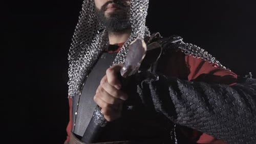 Medieval Warrior Draws Gleaming Sword