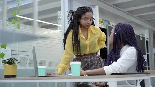 Two Women Collaborating on Laptop in Office