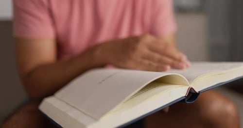 Person Reading Book and Turning Pages