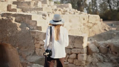 Female Archeologist Examining Ancient Columns
