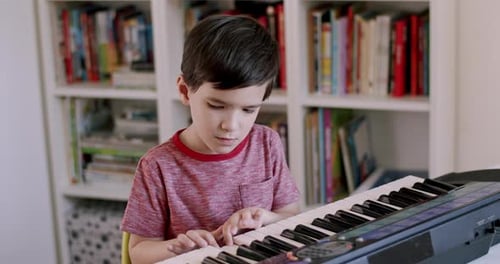 Young Boy Plays Electronic Keyboard at Home