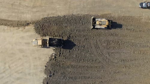 Un camion déplace un substrat pour un bulldozer à aplatir pendant la construction