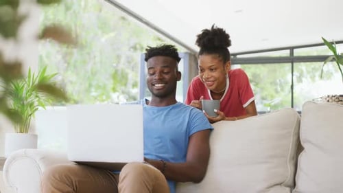 Young Couple Using Laptop on Couch