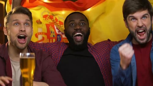 Friends Cheering Victory With Spanish Flag at Bar