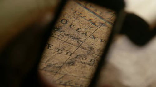 Magnifying Glass Examining a Vintage Map Close Up