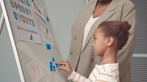 Young Girl Learning Alphabet with Teacher