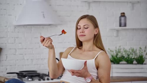 Woman Eating Healthy Salad in Bright Kitchen