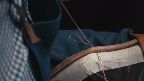 Close Up Shoemaker's Hands Stitches Sole with Awl and Thread