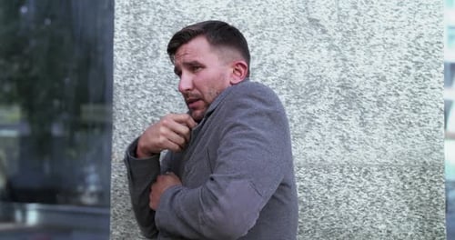 L'homme s'enroule avec une veste pendant une fièvre accompagnée d'une toux sévère
