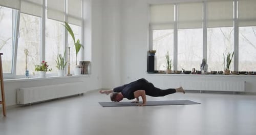 Adult Doing Yoga Routine in Bright Indoor Studio