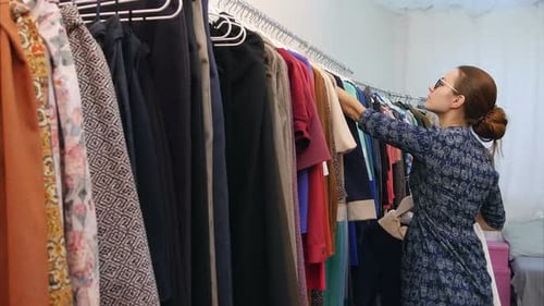 Sales Assistant in Clothing Store Fixing Wardrobe