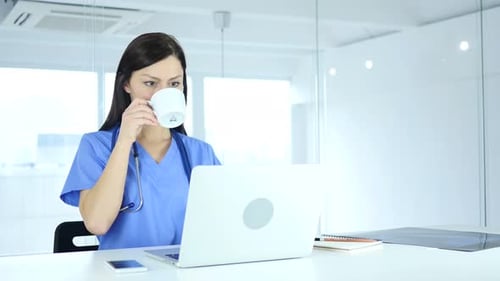 Female Doctor Works on Laptop in Modern Office