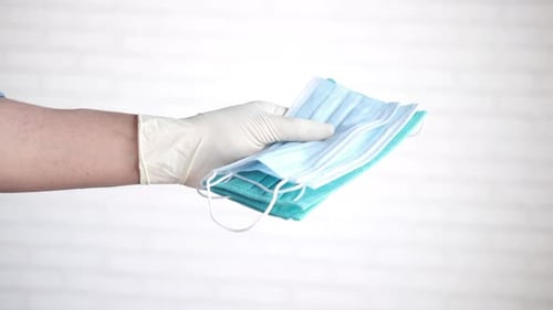Doctor Hand in Medical Glove Holding Protective Surgical Face Mask Close Up