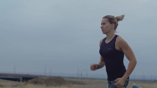 Frau macht das tägliche Training schnell im Freien, Hintergrund, Himmel, Seitenansicht. Frau läuft schnell auf der Straße