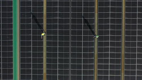 4K Professional engineer using tablet maintaining solar cell panels together on building rooftop.