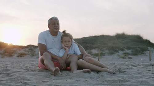 Grandpa and Grandson on the Beach at Sunset