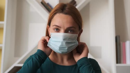Woman Putting on Protective Surgical Mask Close Up