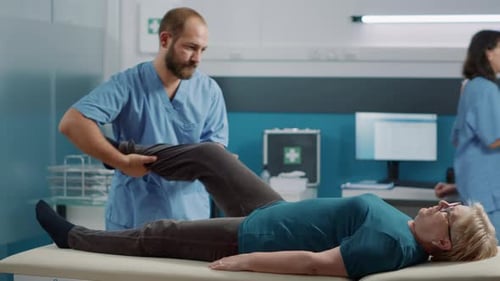 Male Therapist Treating Senior Woman's Leg in Clinic